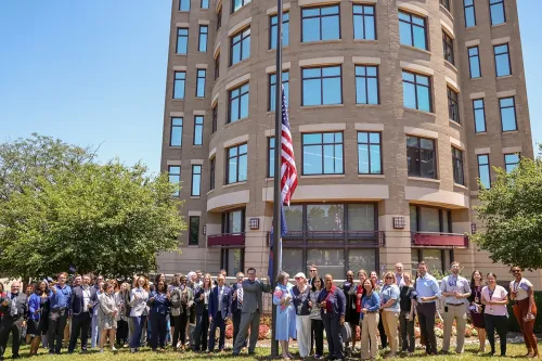 NCUA staff pose with America250 flag anniversary in celebration of America's 250th anniversary