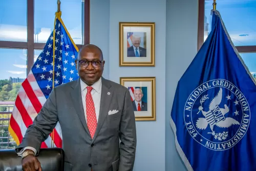 Photo of NCUA Chairman Rodney E. Hood in front of the American and NCUA flags