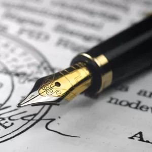 A fountain pen rests on a legal document